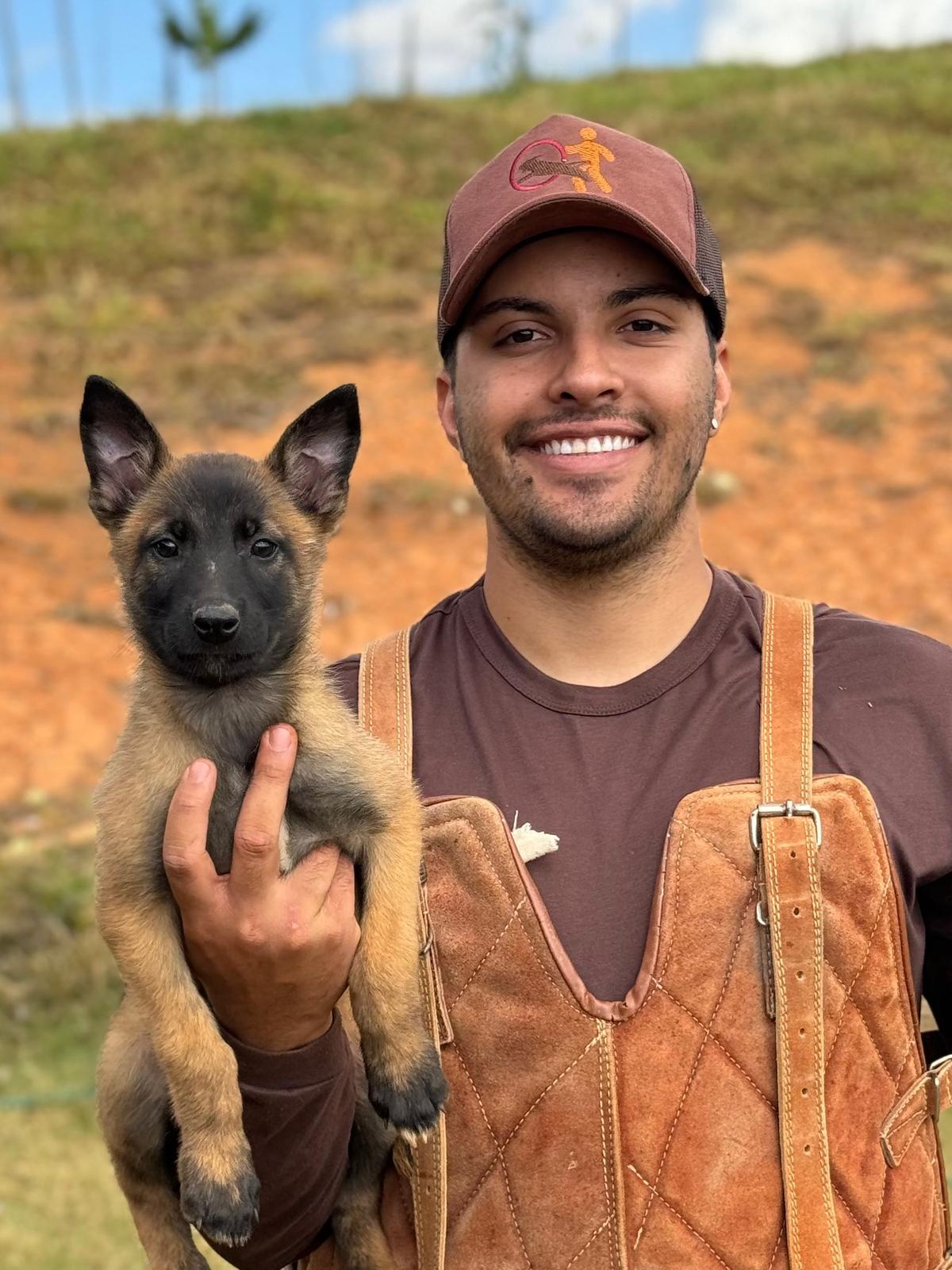 Guilherme, adestrador e fundador da Action Dog, segurando um filhote de pastor belga malinois